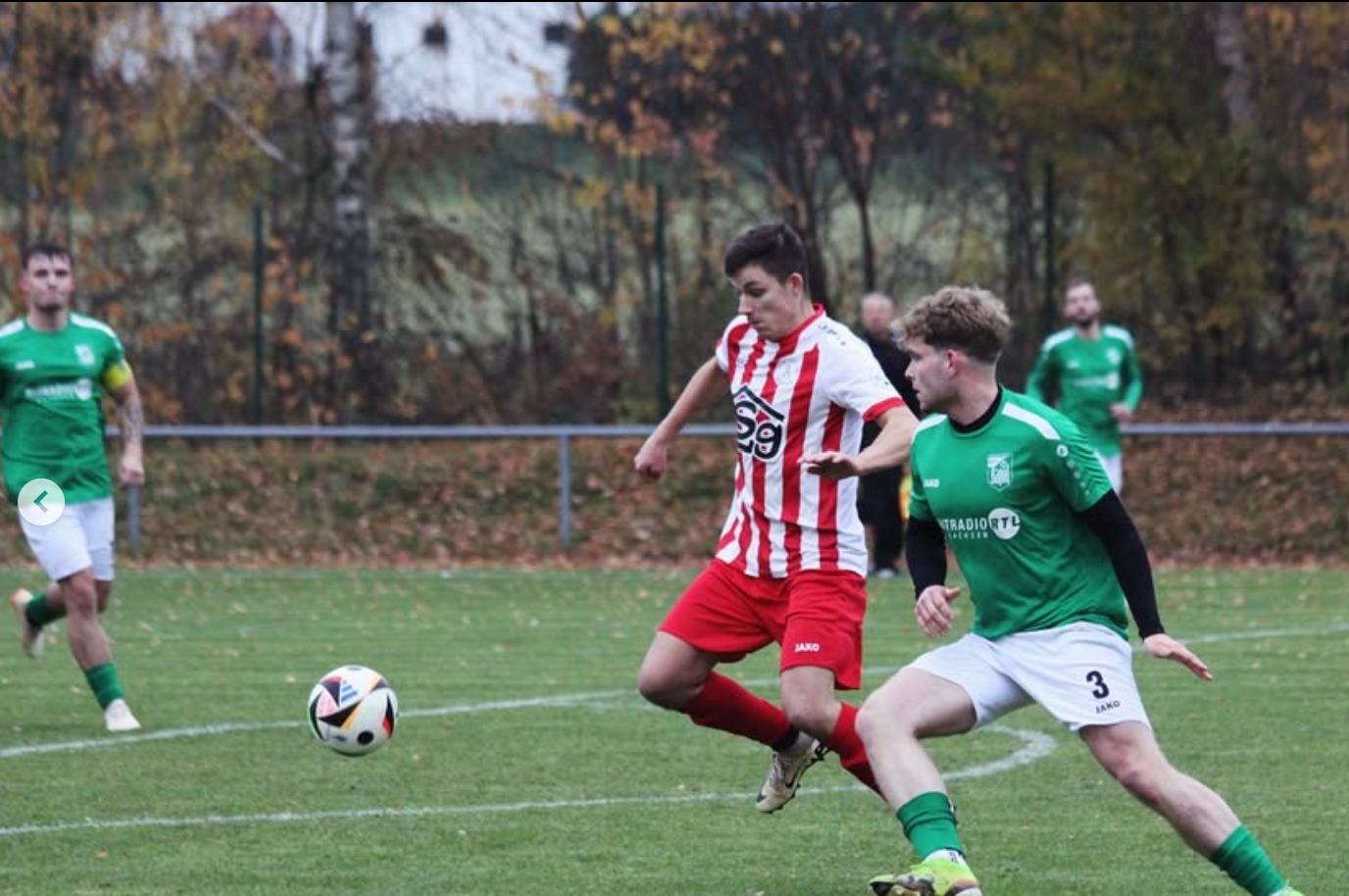 Ein Spieler in Grün stellt sich einem Angreifer der Gastmannschaft entgegen