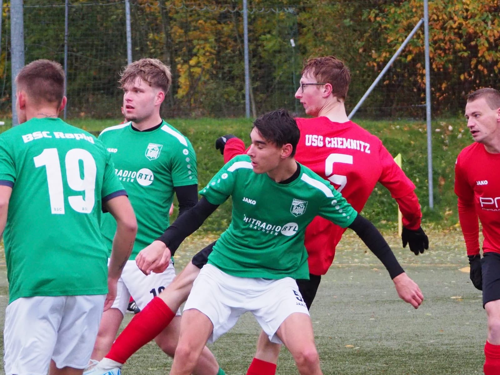 Mehrere Spieler beider Mannschaften warten im Strafraum auf die Hereingabe