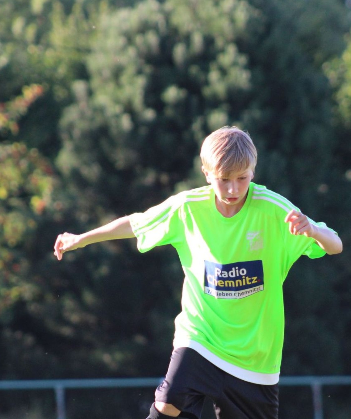 Ein Nachwuchsspieler nimmt den Ball im Herbstlicht an