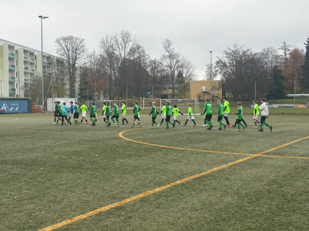 Die Mannschaften gehen nach dem Spiel abklatschend aneinander vorbei